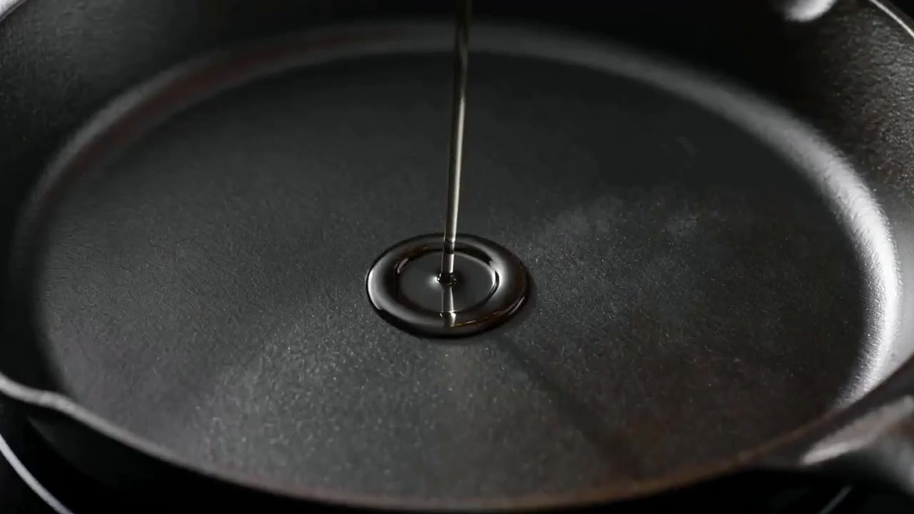 AI video close-up of oil poured into a cast-iron pan