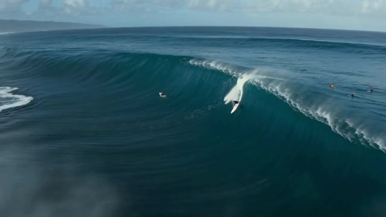 AI video aerial shot of a surfer riding a giant wave